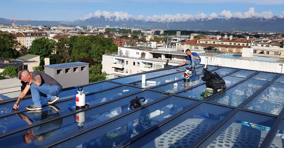 Poseurs de films solaires sur un toit à Genève